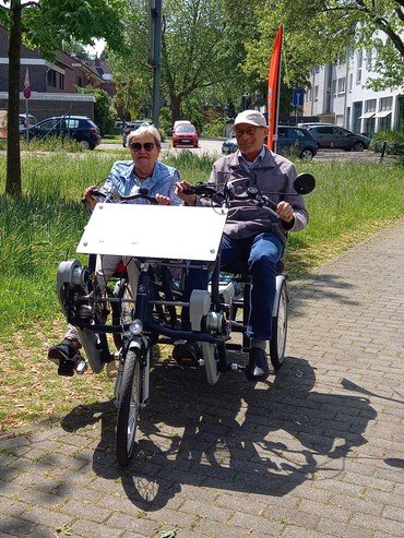 Zwei Senioren fahren auf einem Tandem-Fahrrad.